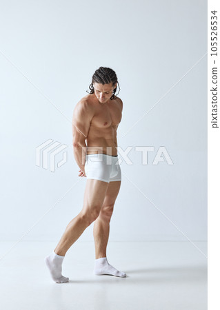 Full-length portrait of handsome mature man with muscular strong body standing shirtless in boxers against grey studio background Full-length portrait of handsome mature man with muscular strong body standing shirtless in boxers against grey studio background 105526534