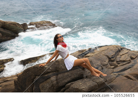 Touristic Drone Shot of Summer Girl on Seaside Rock in White Dress Touristic Drone Shot of Summer Girl on Seaside Rock in White Dress 105526655