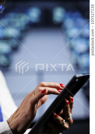 Capable admin using tablet to make sure data remains shielded from security hindrances, safeguarding cloud computing business servers against unauthorized access, close up Capable admin using tablet to make sure data remains shielded from security hindrances, safeguarding cloud computing business servers against unauthorized access, close up 105527138