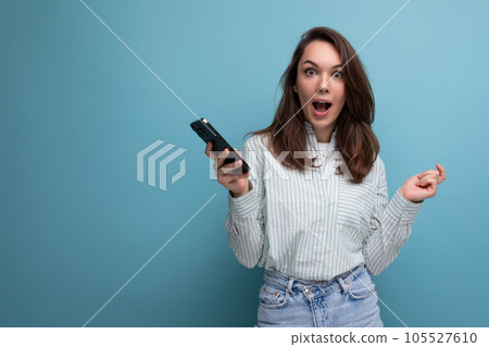 charming brunette young lady uses smartphone to communicate online charming brunette young lady uses smartphone to communicate online 105527610