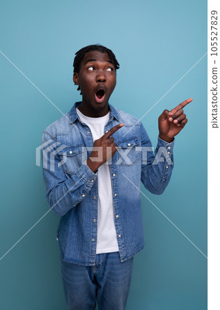 charismatic stylish african man with black dreadlocks points finger to the side charismatic stylish african man with black dreadlocks points finger to the side 105527829