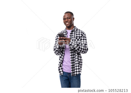 handsome young african man dressed in a plaid shirt talking on the phone 105528213