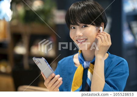 戴著耳機、手持智能手機的年輕女子攝影合作：Credisce（丸善湯堂株式會社） 105528653