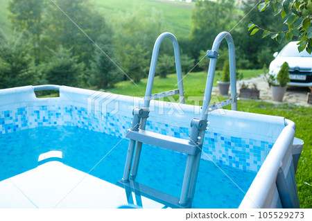 Outdoor pool with blue water in a recreation park. Empty swimming pool with poll stair 105529273