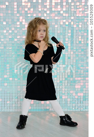 Nice little girl in a black dress singing karaoke 105529309