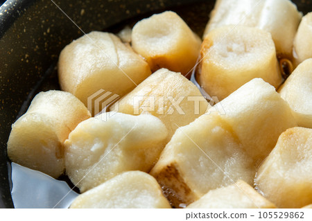 將麵筋與高湯一起放入煎鍋中煮沸,並與雞蛋結合的烹飪場景。 將麵筋與高湯一起放入煎鍋中煮沸,並與雞蛋結合的烹飪場景。 105529862