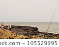 A Relaxed Fisherman Awaits His Catch Against a Beautiful Coastal Backdrop 105529995