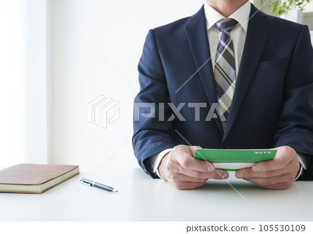 businessman looking at passbook businessman looking at passbook 105530109