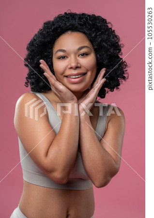 Curly-haired young woman in lingerie on pink background 105530263