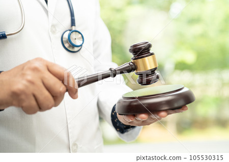 Doctor holding judge gavel, forensic medicine, medical law and crime justice concept. Doctor holding judge gavel, forensic medicine, medical law and crime justice concept. 105530315