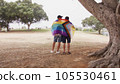 Back shot of two young men hugging with LGBT flag  105530461