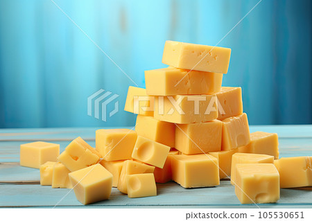 cheddar cheese pieces on blue wooden table and and blue background 105530651
