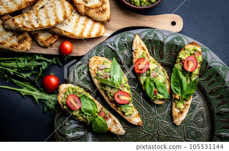 Bruschettas with guacamole and cherry tomatoes Bruschettas with guacamole and cherry tomatoes 105531144