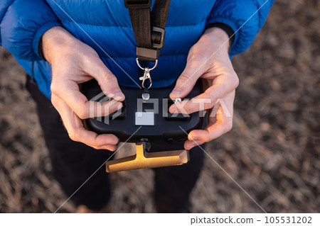 Person holding remote controller Person holding remote controller 105531202