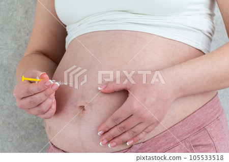 Blood thinners concept. Pregnant woman making injection in stomach Blood thinners concept. Pregnant woman making injection in stomach 105533518