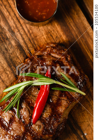 Appetizing juicy steak on a wooden cutting board. Appetizing juicy steak on a wooden cutting board. 105534180