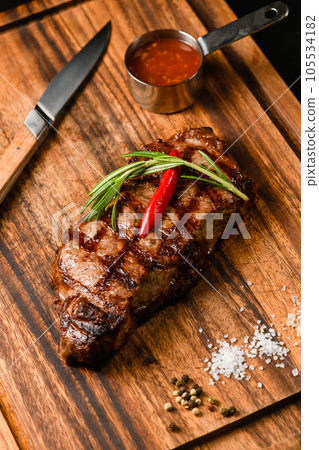 Appetizing juicy steak on a wooden cutting board. 105534182