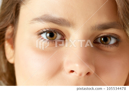 Close-up image of female face, eyes, nose. Woman with well-kept, smooth, glowing skin 105534478