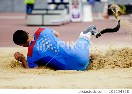 para-athlete long jump, landing in sand at athletics competition, summer sports games para-athlete long jump, landing in sand at athletics competition, summer sports games 105534828