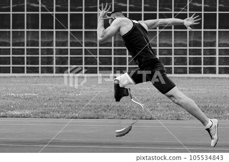 man athlete disability running sprint race at athletics competition, black and white photo man athlete disability running sprint race at athletics competition, black and white photo 105534843