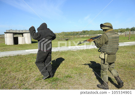 Armed soldier escorting arrested man, training. Ukraine 105534901
