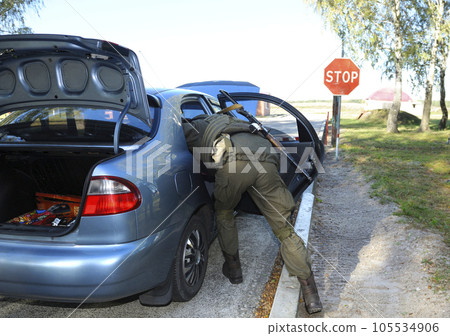 Soldier searching personal belongings of suspect in a stopped car. Checkpoint, training. Ukraine 105534906