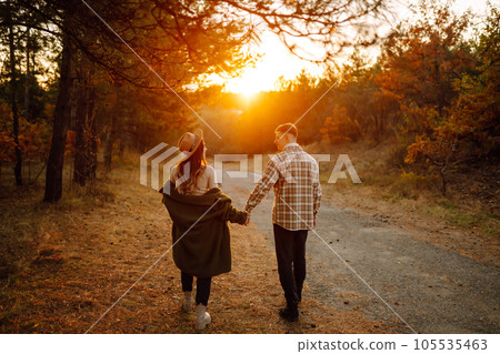 Young couple having fun walking on autumn park at sunset. Lifestyle, relaxation, vacations concept. Young couple having fun walking on autumn park at sunset. Lifestyle, relaxation, vacations concept. 105535463