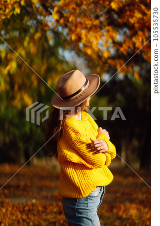 Young woman in a yellow sweater and jeans resting in nature. Fashion, style concept. People, lifestyle. 105535730