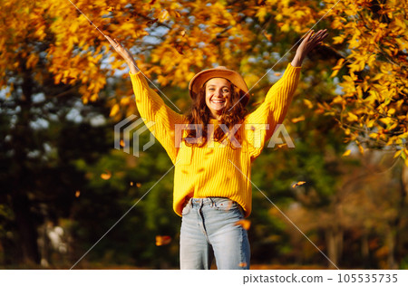 Young woman in a yellow sweater and jeans resting in nature. Fashion, style concept. People, lifestyle. 105535735