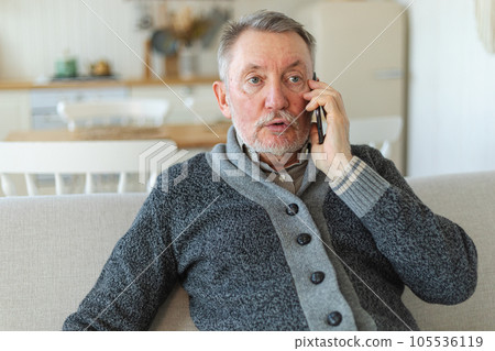 Happy middle aged senior man talking on smartphone with family friends. Older mature grandfather with cell phone talking with grown up children, resting at home. Older generation modern tech usage Happy middle aged senior man talking on smartphone with family friends. Older mature grandfather with cell phone talking with grown up children, resting at home. Older generation modern tech usage 105536119