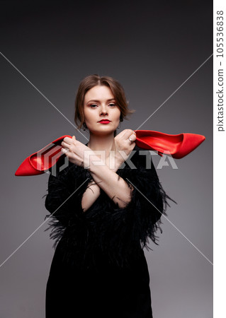 Woman holding red shoes Woman holding red shoes 105536838