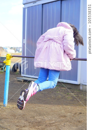 A 3rd grade girl playing with a horizontal bar. Airborne practice. 105538351