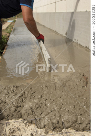 Mason leveling and screeding concrete floor base Mason leveling and screeding concrete floor base 105538383