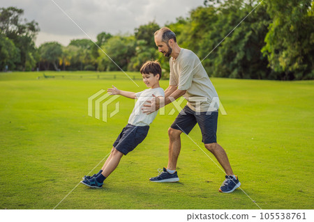 A touching trust exercise as a son falls back into his father's arms, demonstrating unwavering trust and the bond between parent and child A touching trust exercise as a son falls back into his father's arms, demonstrating unwavering trust and the bond between parent and child 105538761