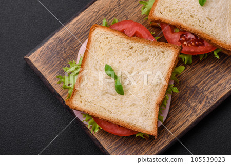 Delicious sandwich with toast, ham, tomatoes, cheese and lettuce Delicious sandwich with toast, ham, tomatoes, cheese and lettuce 105539023