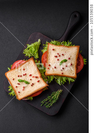 Delicious sandwich with toast, ham, tomatoes, cheese and lettuce Delicious sandwich with toast, ham, tomatoes, cheese and lettuce 105539038
