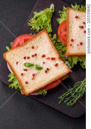 Delicious sandwich with toast, ham, tomatoes, cheese and lettuce 105539042