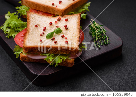 Delicious sandwich with toast, ham, tomatoes, cheese and lettuce 105539043