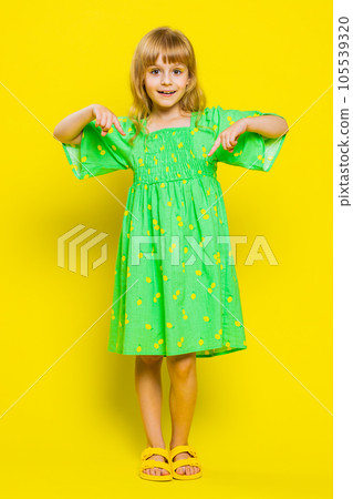 Child girl kid pointing with fingers at copy space below for advertising, like, subscribe, follow 105539320