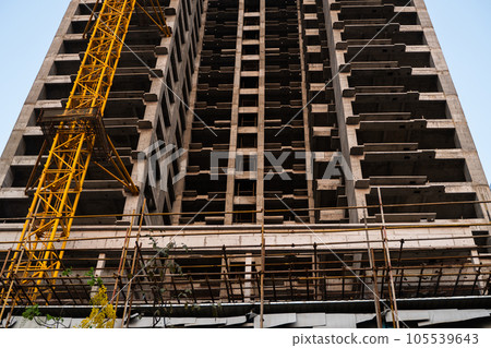 Construction of monolithic building for residential house, office or apartment. Construction site, high-rise, facade of multi-story building. 105539643