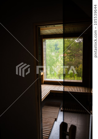 Interior of Finnish sauna, classic wooden sauna with hot steam. Wooden interior baths, wooden benches and loungers, spa complex. Interior of Finnish sauna, classic wooden sauna with hot steam. Wooden interior baths, wooden benches and loungers, spa complex. 105539644