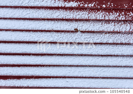 Wet snow powdered boards on burgundy wooden wall. Wet snow powdered boards on burgundy wooden wall. 105540548