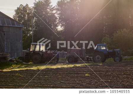 Farmer prepares wheeled agricultural tractor for spraying chemicals on crop. Farmer prepares wheeled agricultural tractor for spraying chemicals on crop. 105540555