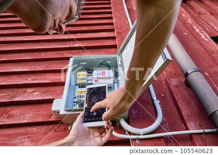 Taking readings from an electric meter located outdoors, using photography with camera on your phone. 105540623