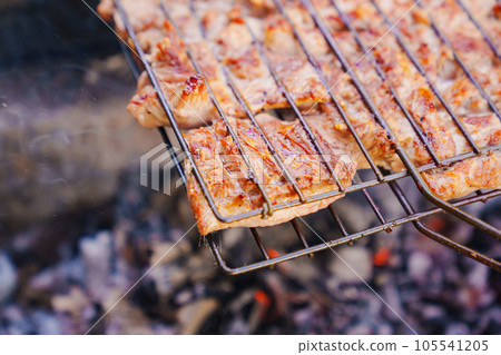 pieces of turkey meat on the grill grate.  105541205