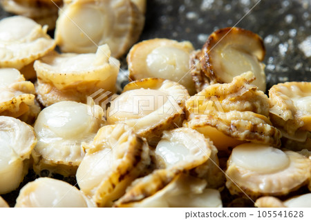 煮扇貝在煎鍋中煎炸的烹飪場景特寫。 煮扇貝在煎鍋中煎炸的烹飪場景特寫。 105541628