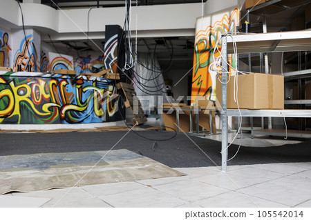 Neglected building in state of disintegration crumbling down, looking messy and deserted. Empty abandoned warehouse with garbage and graffiti spray paint, damaged grungy space. Neglected building in state of disintegration crumbling down, looking messy and deserted. Empty abandoned warehouse with garbage and graffiti spray paint, damaged grungy space. 105542014