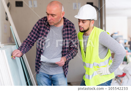 Adult interior designer giving instructions to construction team foreman Adult interior designer giving instructions to construction team foreman 105542233