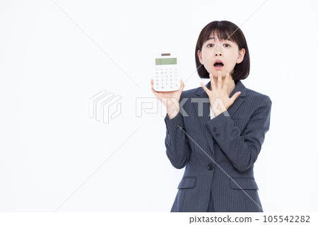 驚訝的三十多歲的女人在白色背景前拿著計算器 驚訝的三十多歲的女人在白色背景前拿著計算器 105542282