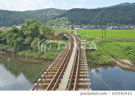 A single track running through the countryside in midsummer 105542413